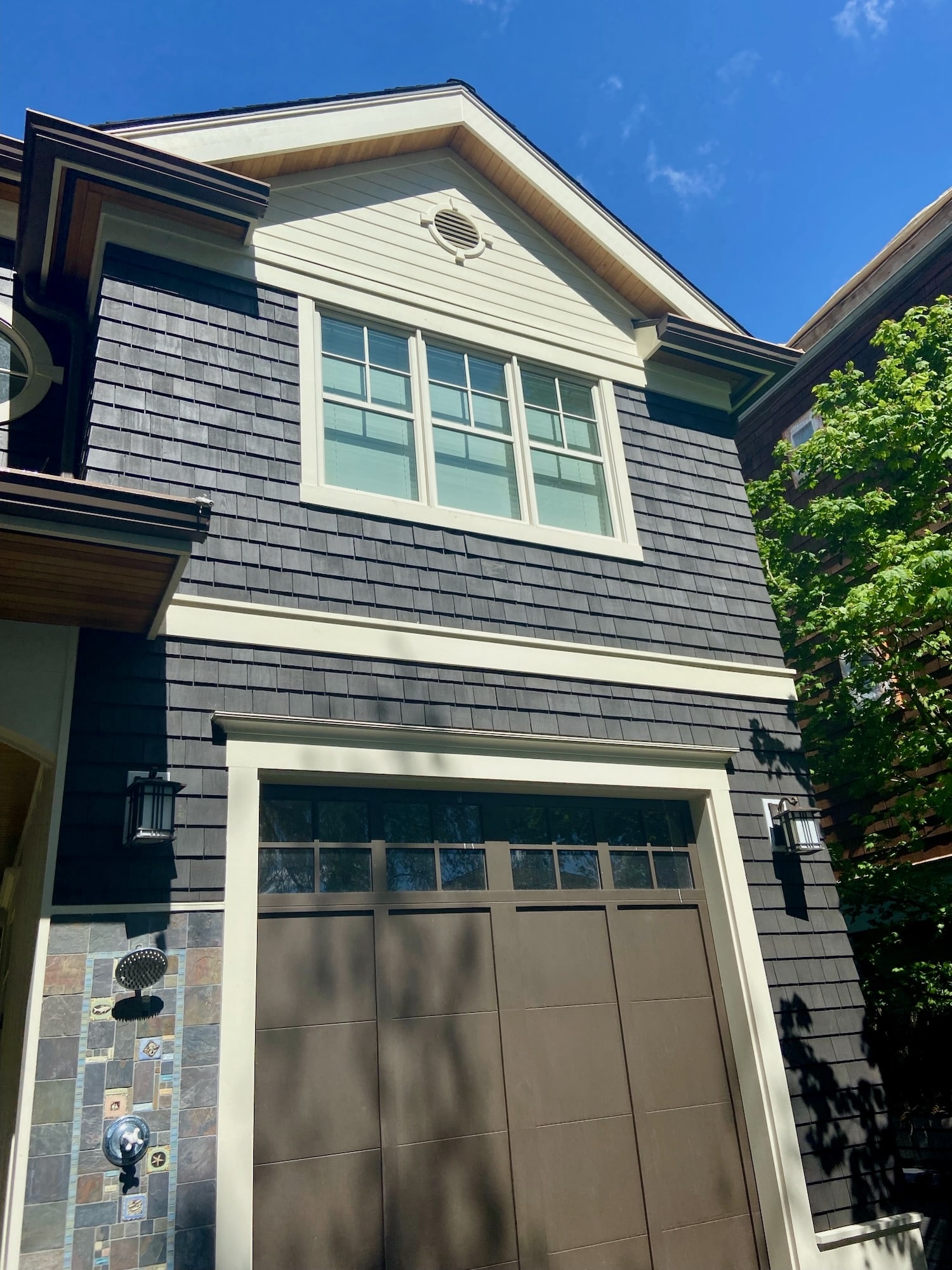 Shingle siding with rebuilt gable trim, window casing and garage header trim in bright Seattle sun
