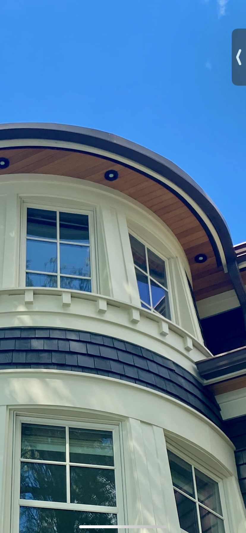 Curved turret with cedar soffit, dentil detailing and painted window casings on a Seattle home