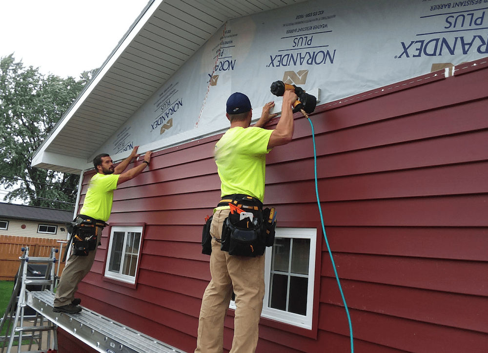 Professional siding installation crew working on a Seattle home exterior